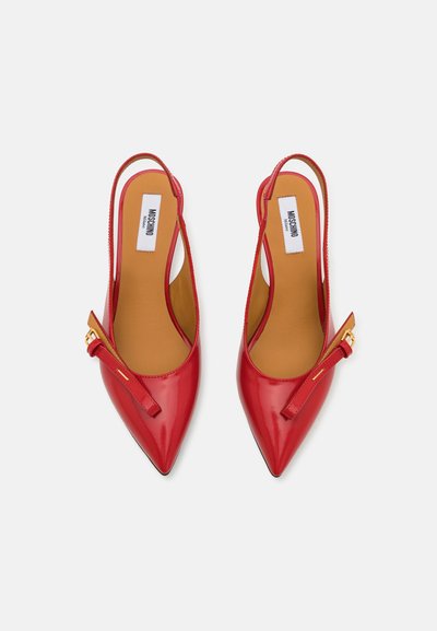 Punane patendeeritud nahast slingback-kontsaga kingad terava varbaga, millel on väike recess ja õhuke rihm. Sile tekstuur beeži sisetallaga.