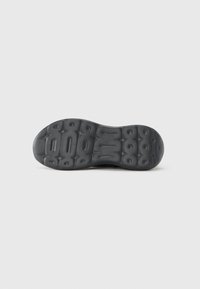 Musta urheilukengän pohja, jossa on teksturoitu pito, pyöreillä nystyröillä ja urilla pitoa varten. Sileät reunat ja minimaalinen yksityiskohdointi.