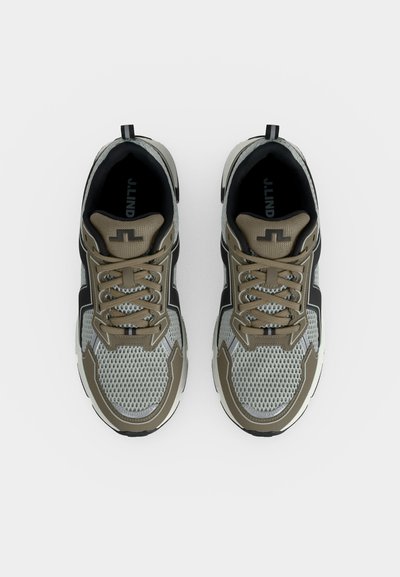 Une paire de chaussures de sport grises et beiges avec dessus en mesh et lacets, vues de dessus sur fond blanc.