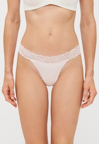 String en dentelle rose clair, avec une taille en dentelle florale délicate et un tissu corporel lisse pour le confort et l'ajustement.