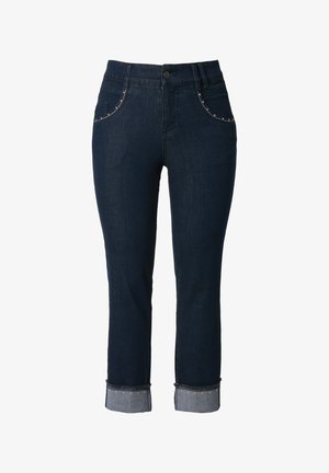 Jeans in denim blu scuro con vita media, tasche decorate e orli arrotolati che mostrano un contrasto di denim più chiaro.