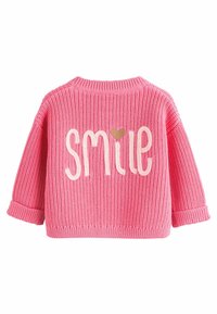 Pull en maille rose avec le mot "SMILE" en crème et un petit cœur en accent, manches longues, et bords côtelés pour les poignets et l'ourlet.