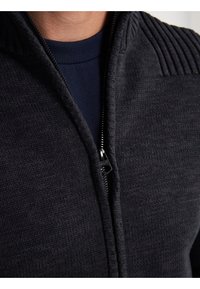 Mörk marinblå zip-up tröja med ribbad krage och slät yta. Har en robust dragkedja och kontrasterande innerkrage.