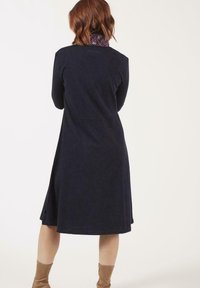 Robe A-line marine en tissu texturé, dotée d'un col floral, de poches latérales et d'un ourlet à la hauteur du genou. Design simple et élégant.