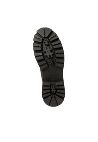 Semelle de botte en caoutchouc noir avec des crampons profonds et un logo circulaire au centre. La semelle présente un design exagéré et robuste pour une meilleure traction.