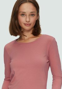 Langärmliges, enganliegendes Oberteil aus weichem rosa Baumwoll-Mix, mit rundem Halsausschnitt und glatter Textur, ideal zum Layering oder für den casual Look.
