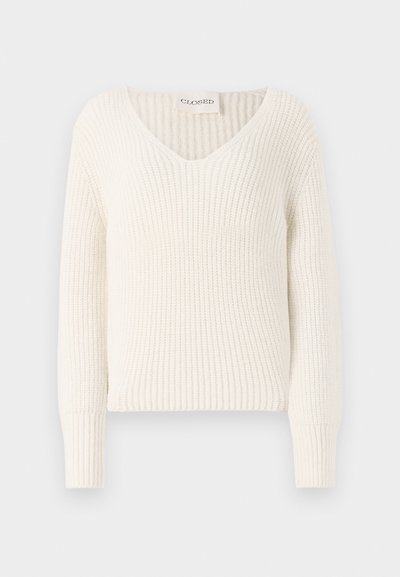 Balts, ribots adīts džemperis ar V-veida kakla izgriezumu, garām piedurknēm un brīvu piegriezumu. Uz apkakles ir uzraksts "CLOSED".