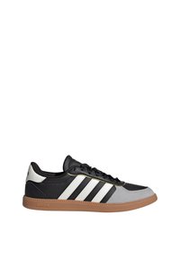 Čierne a šedé športové tenisky s tromi bielymi pruhmi, hladkým koženým zvrškom, gumovou podrážkou, šnurovacími detailmi a jemnými zlatými akcentmi.