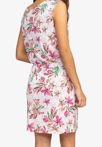 Valkoinen kukkamekko, jossa on vaaleanpunaisia ja vihreitä kuvioita, lyhyet hihat, vyötäröltä kiristetty ja polvipituinen helma. Sulava, kevyt kangas.