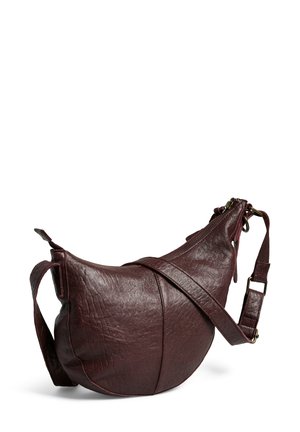 Sac bandoulière en cuir bordeaux avec une forme incurvée, surface texturée et fermeture éclair. Comprend une sangle réglable.
