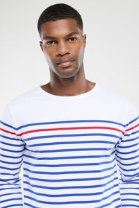 Hvid langærmet skjorte med blå og røde vandrette striber, lavet af et glat stof med en rund halsudskæring og tætsiddende design.