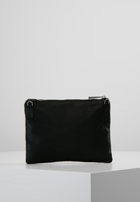 Black rectangular pouch with top zipper and two small loop attachments on each side, displayed on a white pedestal against a gray background.