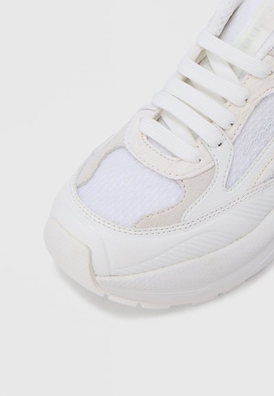 Αθλητικό παπούτσι με άνω μέρος από λευκό διχτυωτό ύφασμα και σουέτ με υφασμένα διακοσμητικά, στρογγυλή μύτη και επίπεδα κορδόνια. Ελαφρώς επενδεδυμένη σόλα για άνεση.