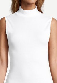 Haut blanc sans manches avec un col montant haut, fabriqué à partir d'un tissu lisse et extensible. Le design est sans couture au niveau des épaules et du torse.