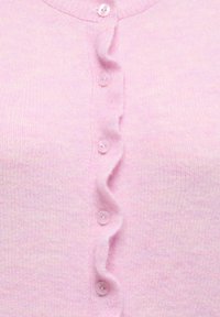 Pale pink cardigan made of soft knit material, featuring a button-up front with ruffled edges and six round, light pink buttons.