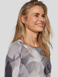 Gray patterned sweater featuring abstract shapes in shades of gray and white, with a round neckline and subtle embellishments.