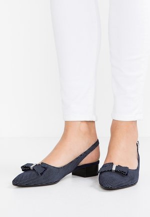 Ballerines à talons slingback bleu marine avec motif à pois, bout pointu et détail nœud. Caractéristiques d'un petit talon carré et d'un tissu texturé.