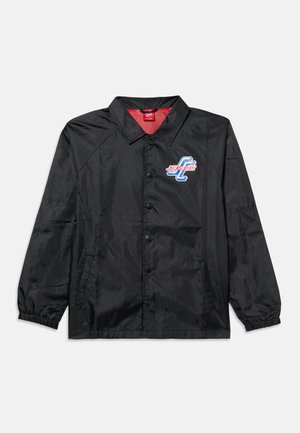 Veste noire légère à boutons, avec col, poignets élastiques, poches latérales, et petit logo Santa Cruz bleu et rouge sur la poitrine.