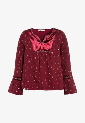 Pigebluse med lange ærmer i mørkerød med lille blomsterprint, rødt velourgreb, broderede detaljer og udvidede manchetter.