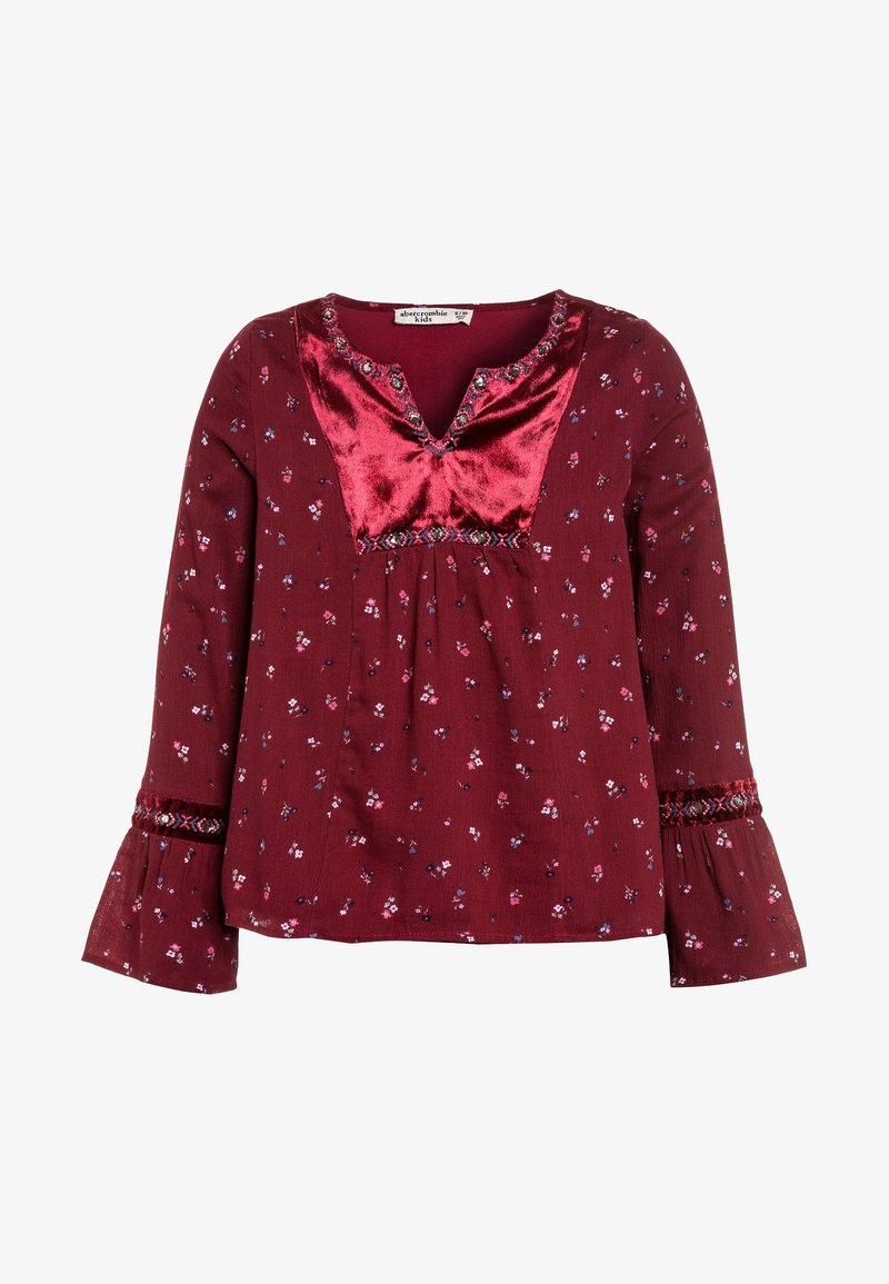 Blusa de manga larga para niña en color granate con pequeño estampado floral, pechera de terciopelo rojo, detalles bordados y puños acampanados.