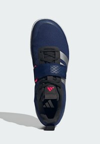 Námořnická sportovní obuv s textilním svrškem, černými doplňky, stříbrnými pruhy a růžovým zapínáním. Obsahuje polstrovanou podrážku.