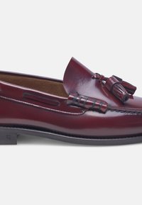 Mocassini in pelle bordeaux con punta arrotondata, nappine decorative e dettagli in cucitura; una silhouette elegante e una texture liscia.