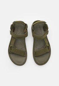 Olivengrønne sandaler med flad sål, justerbare stofremme og en struktureret fodseng for godt greb. Designet til komfort og funktionalitet.