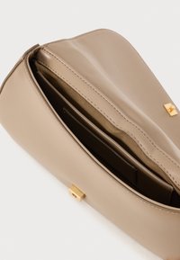 Bēša sintētiskās ādas soma ar gludu tekstūru, viena nodalījuma, un ar zelta aparatūru. Iekšpusē ir kartes slots.