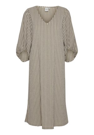 Femme portant une robe à carreaux beige et noire avec un col en V et une ceinture nouée à la taille, montrée des épaules jusqu'aux hanches.