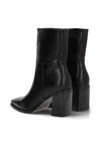 Botines de cuero negro hasta el tobillo con un alto tacón cuadrado, textura suave, punta afilada y un discreto detalle de costura a lo largo de la costura.
