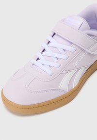 Baskets en daim lilas avec accents blancs, présentant un bout rond, des lacets plats et une semelle en caoutchouc gomme. Comprend une sangle à velcro.