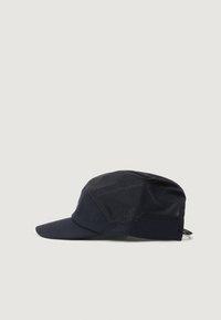 Cappello blu scuro realizzato in tessuto leggero con superficie texturizzata, dotato di una visiera corta e pannelli in rete per la traspirabilità. Dettaglio del logo visibile.