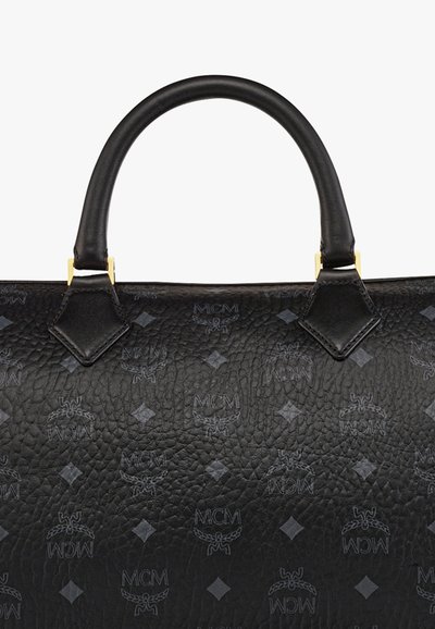 Borsa a mano in pelle nera texture con manico arrotondato, caratterizzata da loghi MCM impresso e motivi a diamante. Accessori in metallo di colore oro.