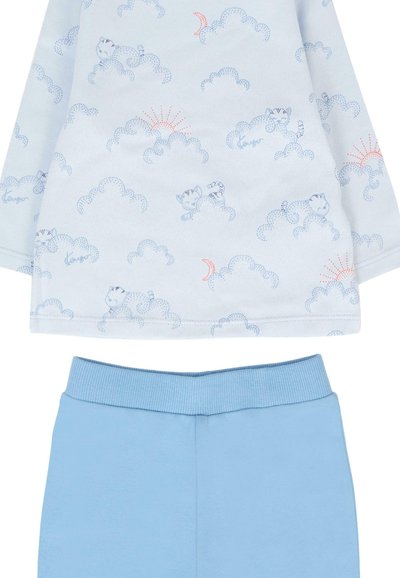 Maglietta azzurro chiaro a maniche lunghe con motivi di nuvole e gatti, abbinata a pantaloni azzurro chiaro con vita a coste.