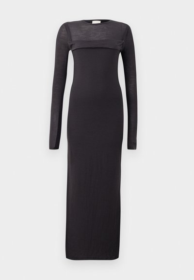 Čierne šaty s dlhým rukávom, priliehavého strihu, s okrúhlym výstrihom a priesvitnou horizontálnou panelou cez hruď. Mäkký, ľahký materiál.