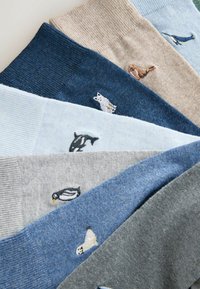 Šešios kojinės poros įvairių spalvų, su raukšlėtomis tekstūromis ir siuvinėtomis jūrų gyvūnų dizainais, įskaitant ruonius ir pingvinus.