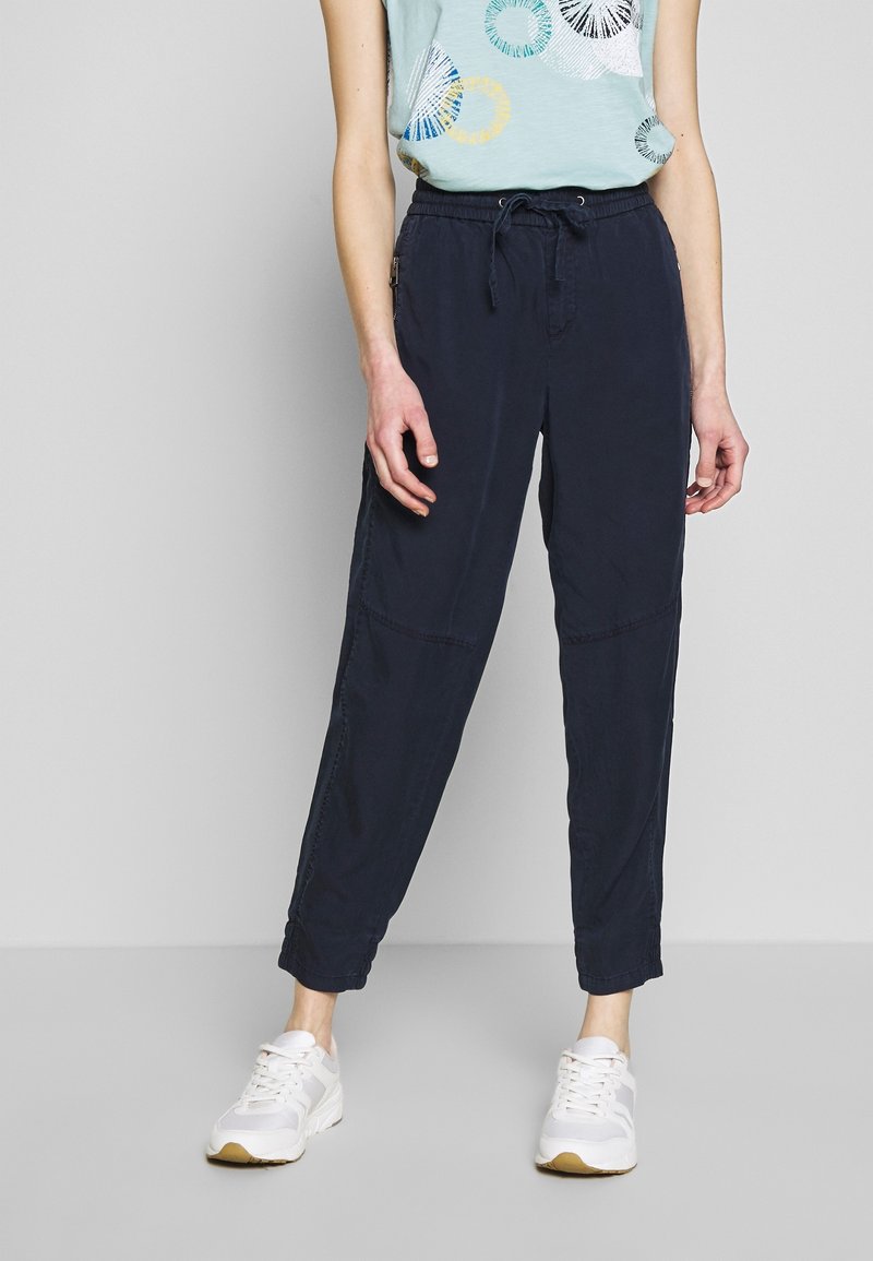 Marine casual broeken met een elastische taille en tapse pijpen, voorzien van zijzakken. Gepaard met een lichtblauw mouwloos top met kleurrijke patroonaccenten.