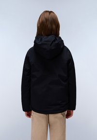 Zwarte capuchonjack met een soepele textuur en elastische manchetten, met een eenvoudig ontwerp en geen zichtbare logo's of patronen, gedragen met beige broeken.