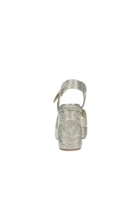 Sandali wedge metallici argento con tessuto testurizzato, fascia alla caviglia regolabile e soletta imbottita. Caratteristico motivo ondulato sul materiale.