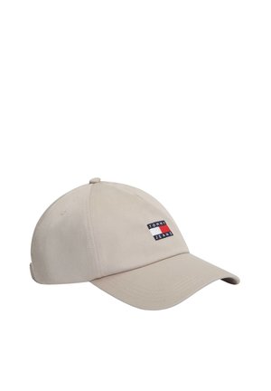 Gorra de béisbol beige con visera curva que presenta un pequeño parche rectangular con un logo en rojo, blanco y azul con el texto "Tommy Jeans".