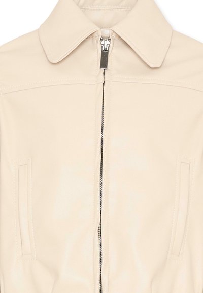 Beige jas met brede kraag, verticale ritssluiting en twee verticale steekzakken op het voorpand.