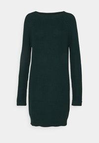 Abito maglione lavorato a maglia verde scuro con scollatura a barchetta, maniche lunghe e polsini a costine. Tessuto testurizzato e orlo leggermente curvato.