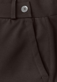 Pantalons en mélange de coton marron avec une fermeture à bouton métallique et des poches latérales, dotés d'une texture lisse et de détails de couture visibles.