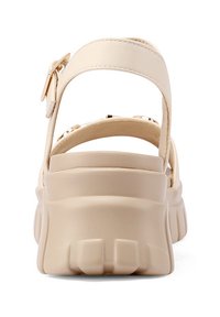 Sandali con piattaforma beige, con tomaia in pelle liscia, ampia cinghia alla caviglia e chiusura regolabile. Suola curva con scanalature testurizzate.