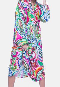 Robe chemise colorée et à motifs avec manches longues, col et coupe décontractée. Présente des verts, roses et bleus vifs sur un fond clair.