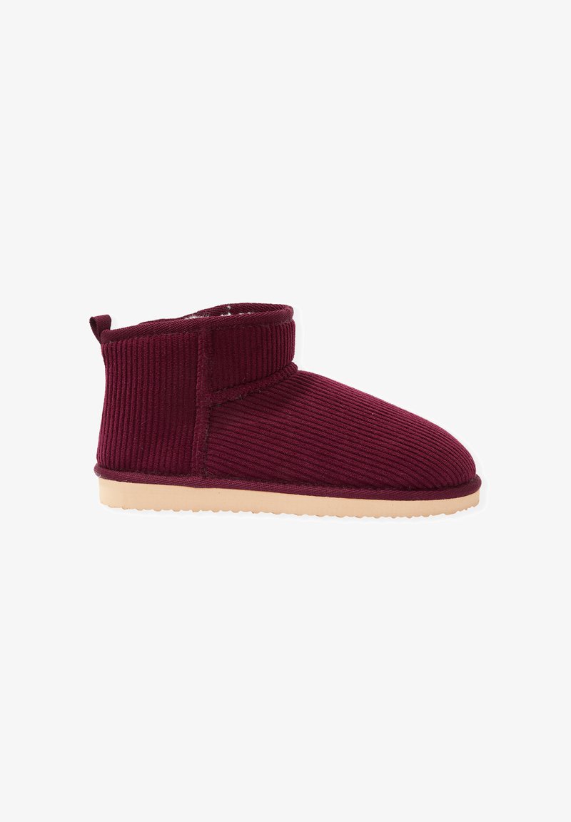 Bottines en velours côtelé bordeaux avec une surface douce et texturée, bout arrondi et semelle en caoutchouc beige flexible. Elles possèdent un col repliable.