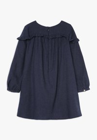 Granatowa sukienka z długim rękawem, z falbanami na dekolcie i guzikami przy mankietach, z zamkiem błyskawicznym z tyłu, luźny krój.