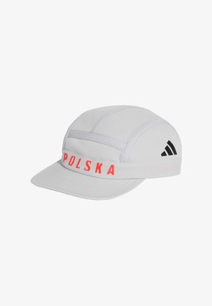 Biała czapka z tkaniny z płaskim daszkiem, na przednim pasku czerwone litery "POLSKA" oraz czarne logo Adidas po boku.