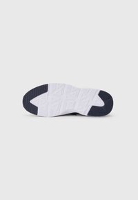 Shoe sole with white and black rubber tread featuring geometric triangle patterns and ribbed sections on toe and heel.
