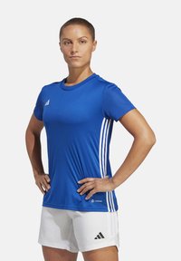 Blue athletic t-shirt with short sleeves, round neck, and white three-stripe design on sides. Worn with white shorts, branded logo on short.